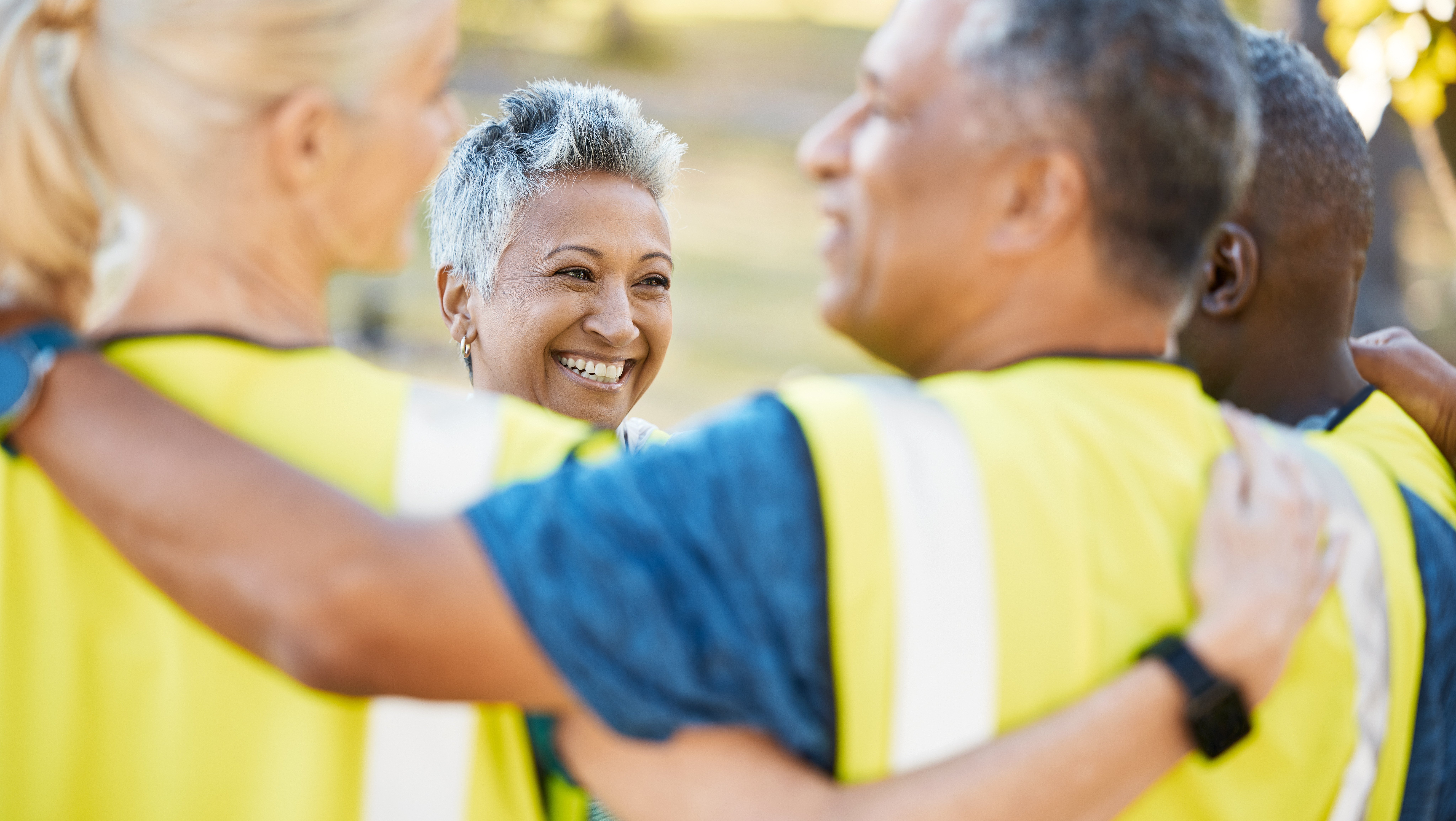 A group of workers in yellow vests smiling
