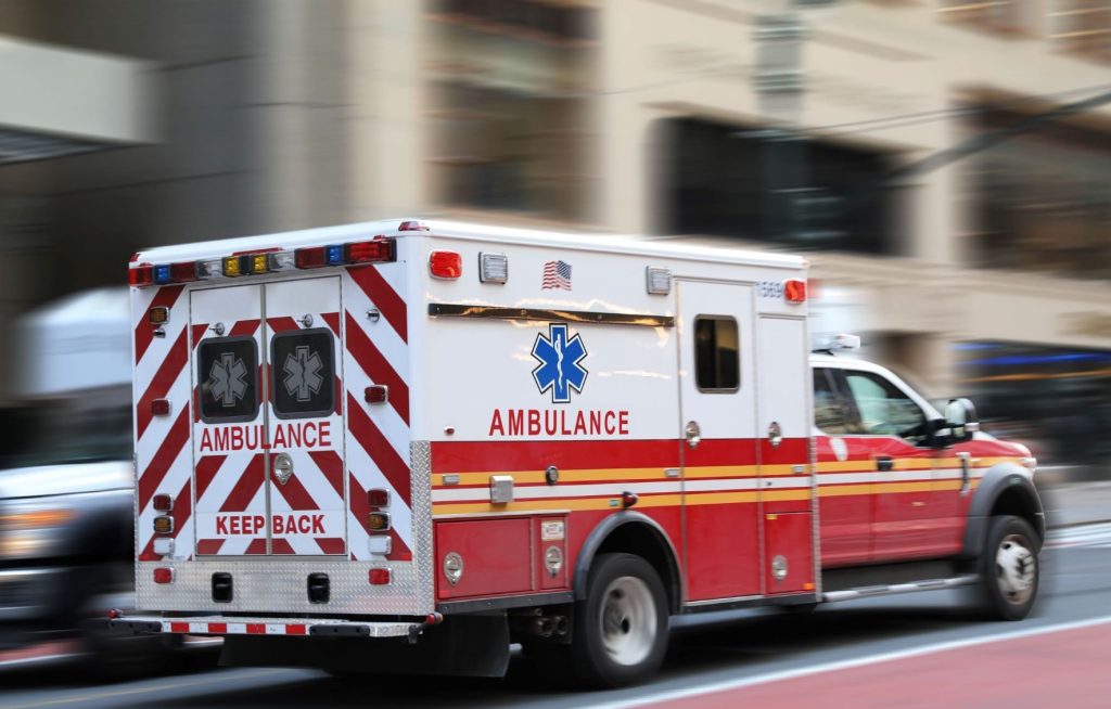 Ambulance driving down an urban street.